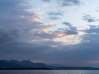 Düstere Bergstimmung am Chiemsee bei Übersee mit leuchtenden Wolkenteilen